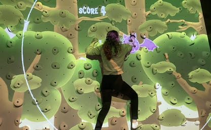 Girl climbing the interactive climbing wall 