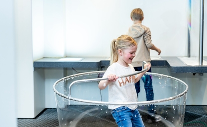 Girl creating a soap bubble